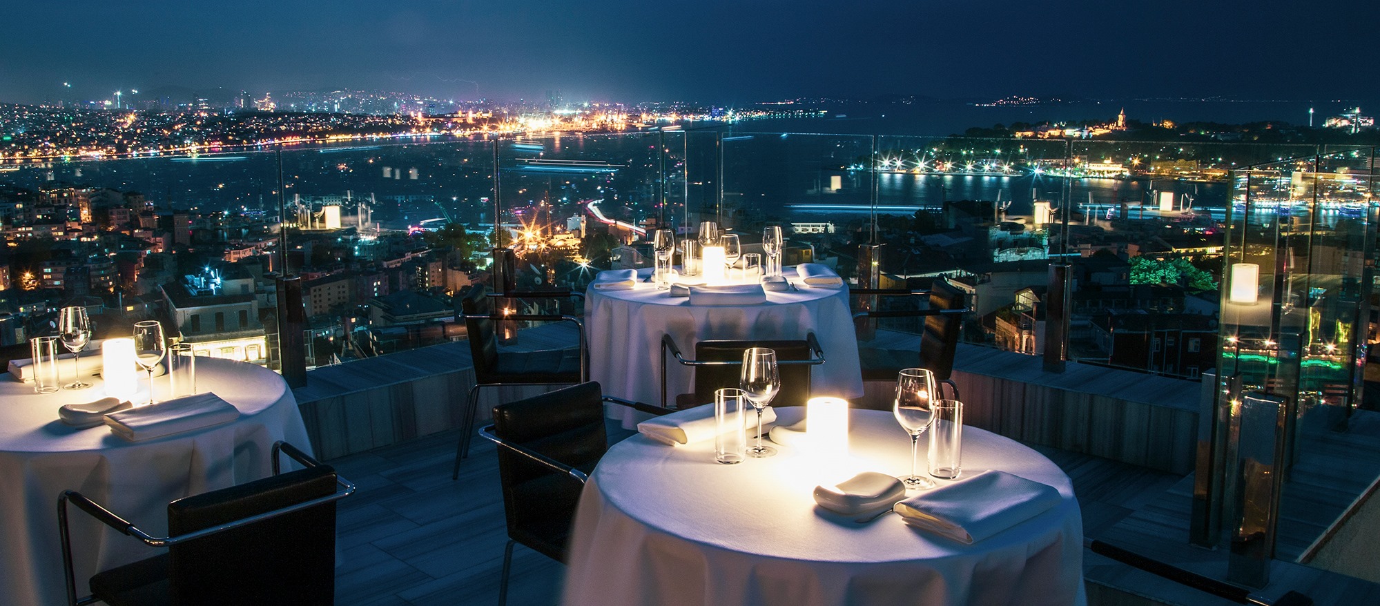 A rooftop dinner table above the Bosphorus at night